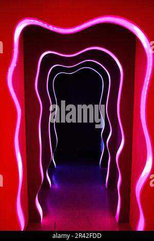 Infinite corridor with red doorways and a black portal Stock Photo