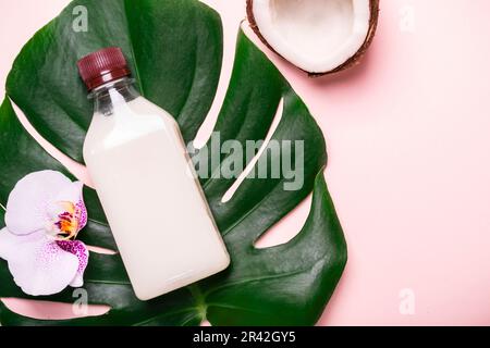 Coconut oil and tropical leaves and flowers. Hair care spa concept Stock Photo