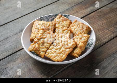 Fried Tempeh or Tempe is a traditional Malay dish snack popular in Malaysian, Indonesian, and Singapore Stock Photo