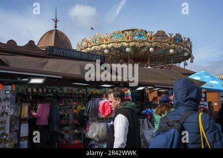 Tourists at the gift shop next to the Carousel of Eiffel Tower in Paris, France. March 25, 2023. Stock Photo