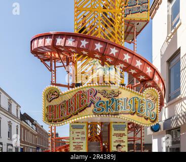 A traditional Helter Skelter ride, with vibrant colours and wonderful signage standing in an urban setting. Stock Photo