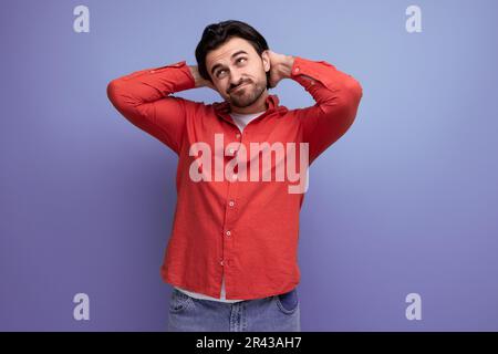 attractive brutal dark-haired 30s man in a red shirt Stock Photo