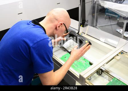 quality control in the production - man checks board for defects - manufacturing in a high tech factory Stock Photo