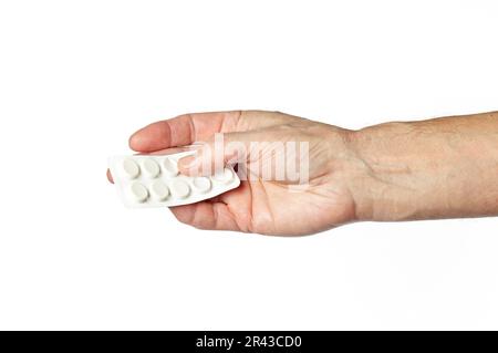 Men's hand holding white pills in common tablets shape isolated on white background. Hand with pills, closeup Stock Photo