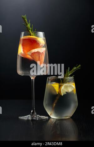 Two tall cocktail glasses with pink gin and tonic garnished with large  crystals of salt on an edge of a glass, large piece of ice, peppermint  Stock Photo - Alamy