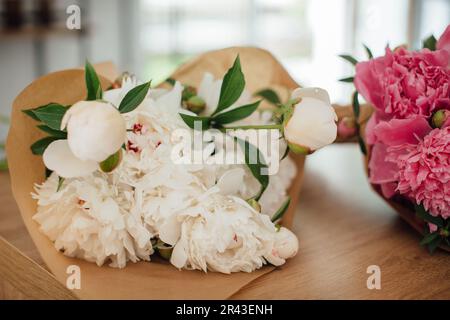 Peonies on a table in a flower shop, close-up. Stock Photo