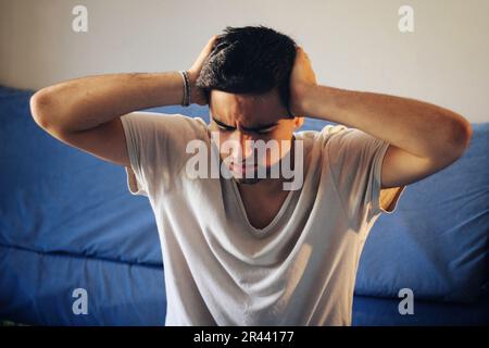 Man dressed in white with a headache. Stock Photo