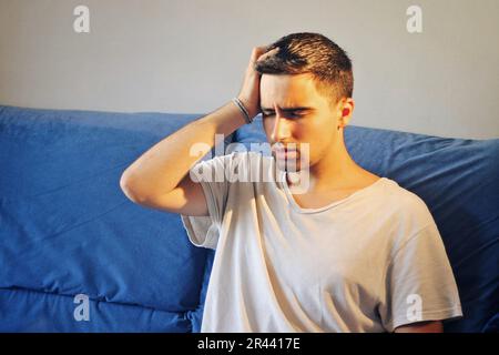 Man dressed in white with a headache. Stock Photo