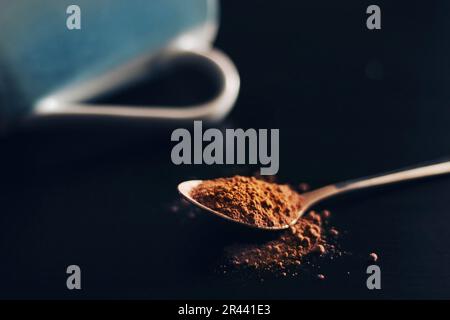 Background of a spoon of cocoa powder and a cup. Stock Photo