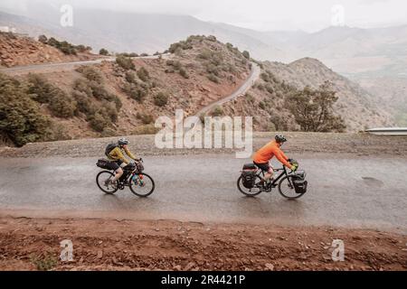 A couple of cyclists biking on the hairpin Tizi n Test pass, Morocco Stock Photo
