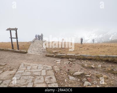 SNEZKA, GIANT MOUNTAINS - April 30, 2023.  : Tourists at the peak of Sniezka in the Giant Mountains in cloudy weather Stock Photo