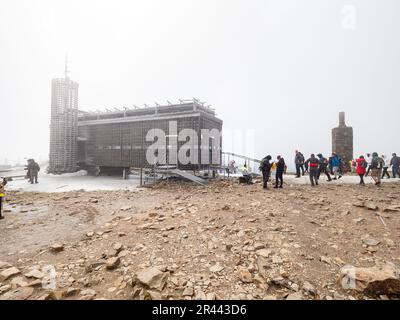 SNEZKA, GIANT MOUNTAINS - April 30, 2023. Ceska postovna building on Snezka hill. Group of people in fog on Snezka in Krkonose National Park. Very bad Stock Photo