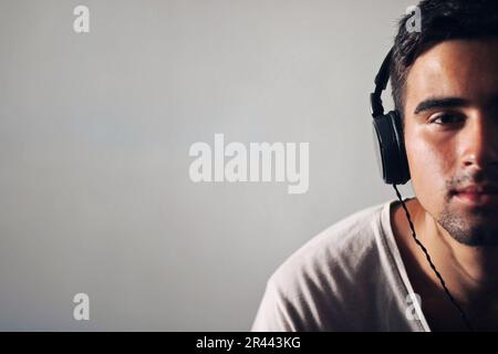 Man dressed in white listening to music. Stock Photo
