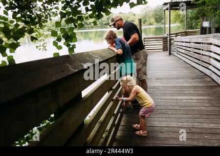 Family looking down off boardwalk into water Stock Photo