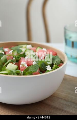 Delicious salad with watermelon, cucumber, arugula and feta cheese on wooden table, closeup Stock Photo