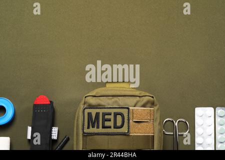 Flat lay composition with military first aid kit on khaki background. Space for text Stock Photo