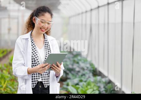 Happy Smiling Scientist Modern Farmer using Tablet Monitor Agriculture Farm Plant Research Working. Stock Photo