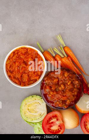 Traditional South African Chakalaka, popular spicy side dish or relish. On mottled grey with and fresh ingredients Stock Photo