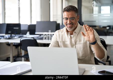 Middle-age Hispanic man using computer remote for business studying, online work Stock Photo