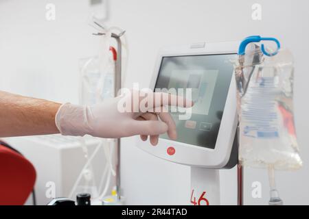 partial view of young man with transfusion set and blood pressure cuff ...