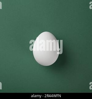 White egg on green pastel background. Copy space. Minimal concept. Stock Photo
