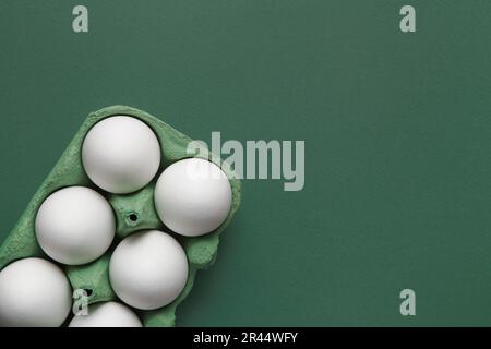 White egg, yolk on green pastel background. Eco Sustainably concept. Stock Photo