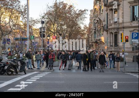 Many pedestrians standing at the traffic light on Paseo de Gracia street in Barcelona, There are many people wearing jackets, it's a bit cold Stock Photo