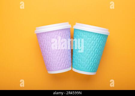 Take-away coffee cups on yellow background. Two coffee to go cups, mockup. Stock Photo