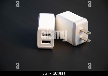 USB charger, white, 2-port type, placed on a black background Stock Photo