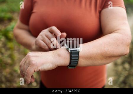 Active sport senior woman checking heart rate after run. Fitness healthy lifestyle concept. Stock Photo