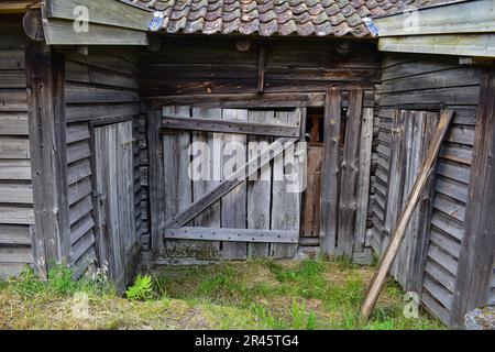 Old dilapidated shed of wooden planks with weathered roof tiles, Norway, Europe Stock Photo