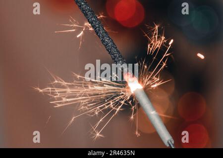 A beautiful view of a sparkler on a blurred bokeh background - Christmas wallpaper Stock Photo