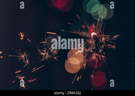 A beautiful view of a sparkler on a blurred bokeh background - Christmas wallpaper Stock Photo