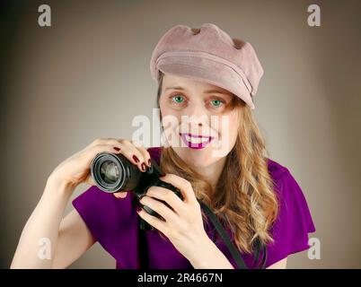 Young teenage woman photographer smiling and holding small digital camera Stock Photo