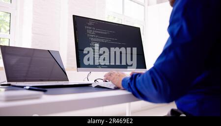 Computer Programmer Writing Program Code On Computer In Office Stock Photo