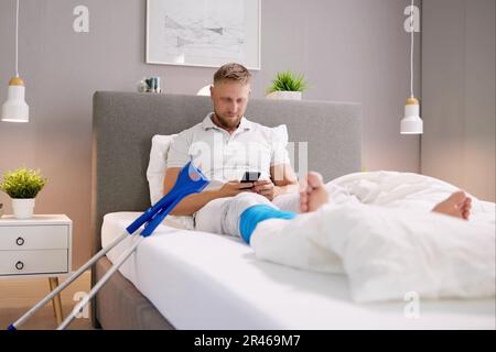 Close-up Of A Man's Broken Leg And Crutches Stock Photo