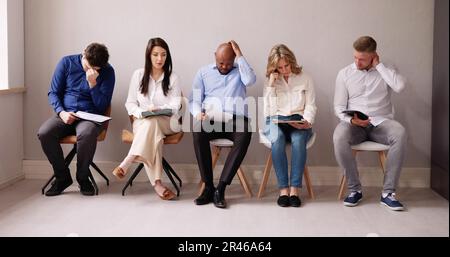 Business People Are Getting Bored While Sitting On Chair Waiting For Job Interview In Office Stock Photo