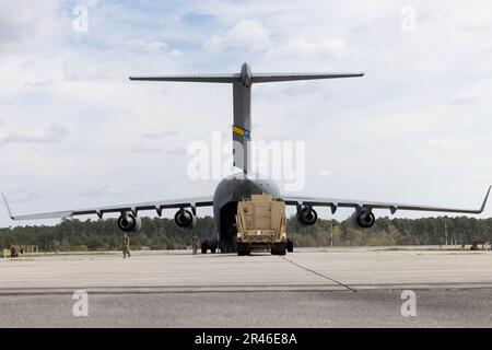 U.S. Marines with Combat Logistics Company 21, Marine Corps Air Station (MCAS) Cherry Point, North Carolina; U.S. Airmen with 16th Airlift Squadron, stationed at Charleston Air Force Base, South Carolina; and U.S. Soldiers with Battery B and Company E, 1st Battalion, 7th Air Defense Artillery stationed at Fort Bragg, North Carolina, load a heavy expanded mobility tactical truck onto a C-17 Globemaster III during exercise Operation Panther Talon at MCAS Cherry Point, North Carolina, March 31, 2023. MCAS Cherry Point’s training facilities, special-use air space, and proximity to Fort Bragg and S Stock Photo
