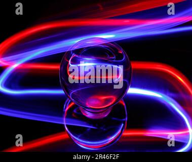 An intriguing red and purple light emanating from a light bulb in a dimly lit setting creating a mysterious aesthetic Stock Photo