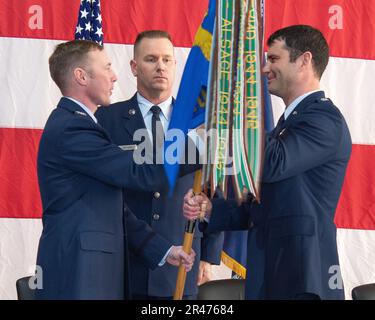 Col. Matthew Robins, 127th Operations Group commander, Selfridge Air National Guard Base, Michigan, hands the 107th Fighter Squadron guidon to Lt. Col. Adam Pauly, incoming commander 107th Fighter Squadron, Feb. 4, 2023 during the unit's change of command ceremony. The passing of the guidon is a symbolic gesture, whereby the outgoing commander passes the guidon back to the group commander and the incoming commander receives it from the group commander. Stock Photo