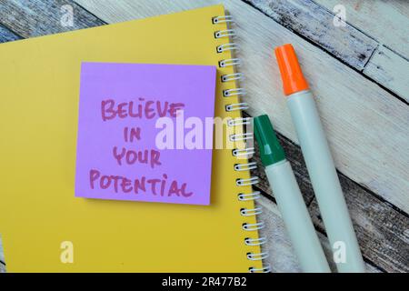 Concept of Believe in Your Potential write on sticky notes isolated on Wooden Table. Stock Photo