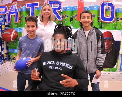 The Rollins family poses for pictures with New England Patriots football player Kyle Dugger during an autograph session Feb. 16 at the Fort Lee Commissary.  More than 100 fans were present for the event that also included giveaways, free hot dogs and sales promotions. Stock Photo