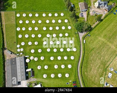 Hay Festival, Hay on Wye, Wales, UK – Friday 26th May 2023 – Aerial view of a field of tipi glamping tents ready for guests this bank holiday weekend adjacent to the Hay Festival site in rural Powys. Photo Steven May / Alamy Live News Stock Photo