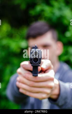 Military man with assault rifle standing inside building, he is ready ...