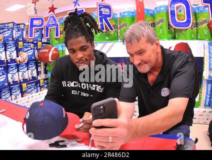 NFL player Kyle Dugger poses for pictures with Jerry Schiftlett during an autograph session Feb. 16 at the Fort Lee Commissary. Stock Photo