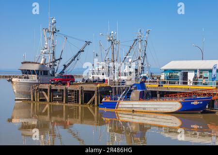 Small jetty in Steveston with fish boats and a whale watching boat in Steveston Canada Stock Photo