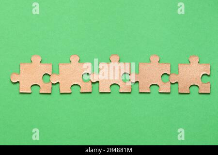 Puzzle on green background. Teamwork, Solving and completing the task. Blockchain technology. Assembling jigsaw puzzle pieces. Decentralized Autonomou Stock Photo