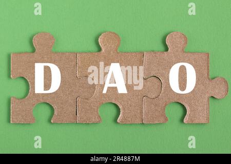 Decentralized Autonomous Organization. Puzzle, word DAO, on green background Stock Photo