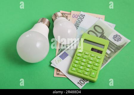 Light bulb, money on green background. Renewable Energy. Environmental protection, renewable, sustainable energy sources. Stock Photo