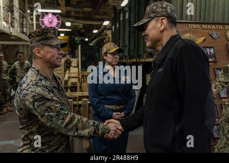 U.S. Marine Corps Lt. Col. Eric Olson, executive officer of the 13th Marine Expeditionary Unit, shake hands with Republic of Korea Navy Vice Adm. Myung Soo Kim, the ROK Navy Fleet Commander, during a ship tour aboard the amphibious assault ship USS Makin Island (LHD 8) in Busan, South Korea on March 24, 2023. Celebrating the 70th anniversary of the U.S.-ROK Alliance, Ssang Yong 2023 strengthens the Alliance through bilateral, joint training, contributing toward the ROK's combined defense of the Korean Peninsula and increasing the readiness of the U.S.-ROK Alliance. Stock Photo